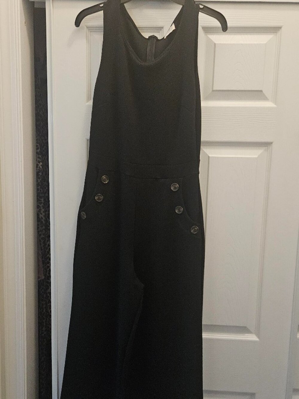 Black jumpsuite with wooden colored buttons, flare leg